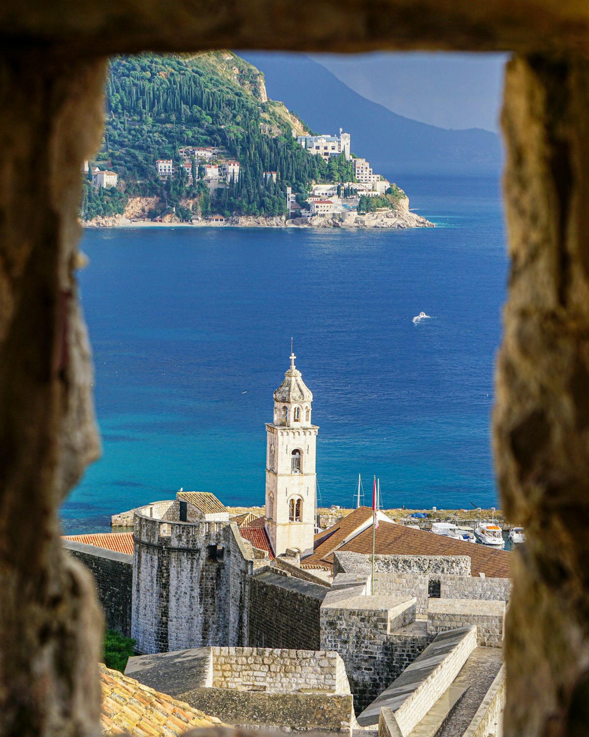 Menara lonceng batu dan tembok kota tua Dubrovnik di tepi Laut Adriatik