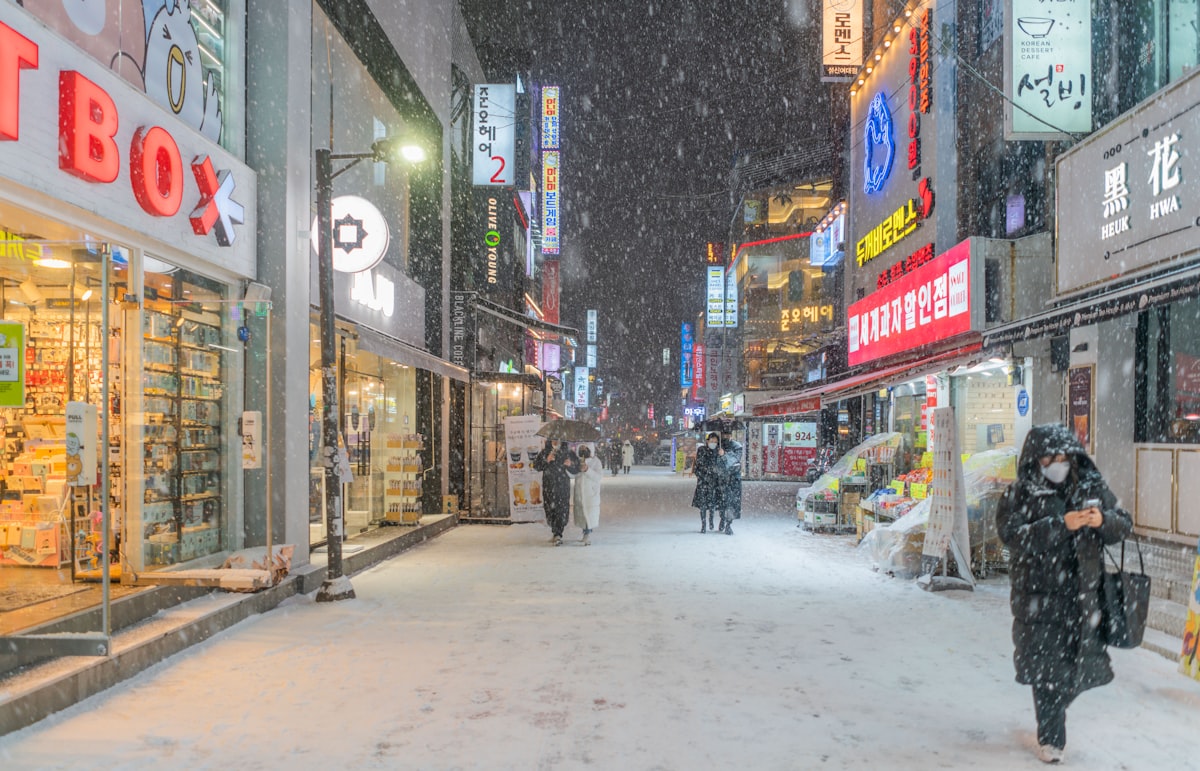 Wanita berjalan di jalan bersalju di Seoul saat musim dingin